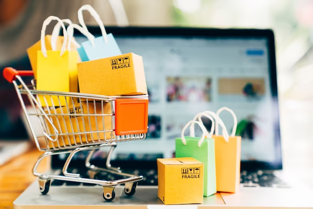 Mini shopping cart and shopping bag on top of laptop keyboard.