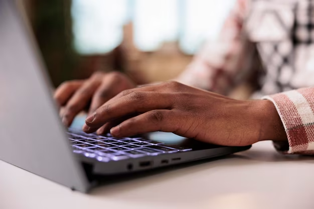 Typing hands on laptop keyboard